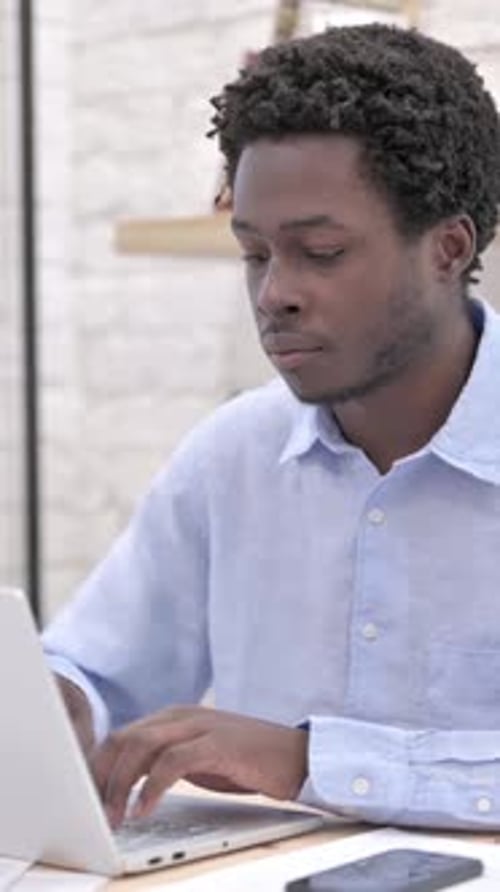 Man Typing on Laptop in Indoor Environment