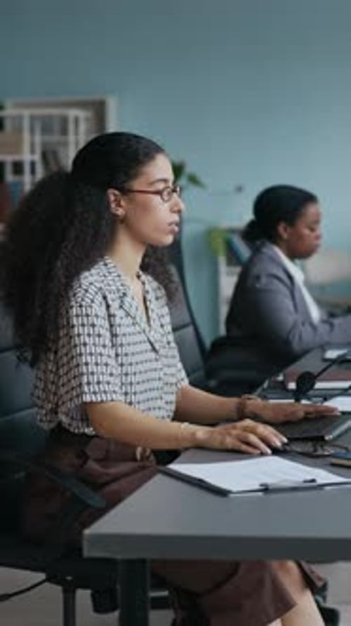 Woman Putting Headset on Head, Taking Notes and Consulting Online Client