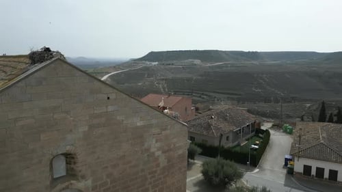 Aerial Shot of Pair Of Storks Sits In a Big Nest On the Roof of a Church