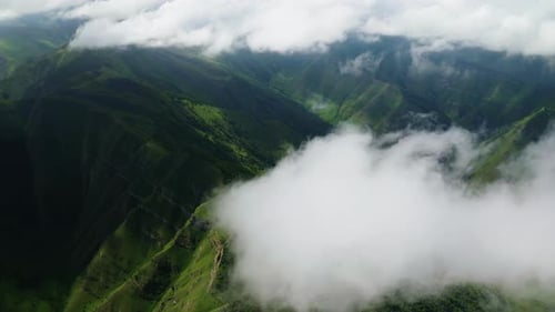 Verdant Mountain Valleys Shrouded in Mist Aerial View of Green Valleys and Hills Veiled By Clouds