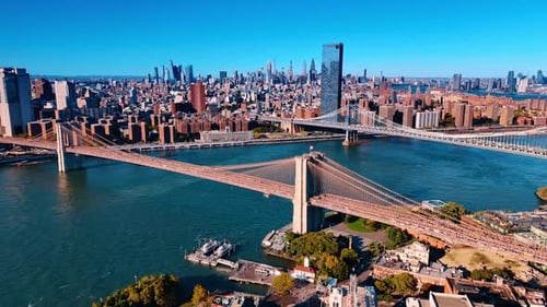 Iconic scenery of the Brooklyn Bridge and Manhattan Bridge over the blue waterscape