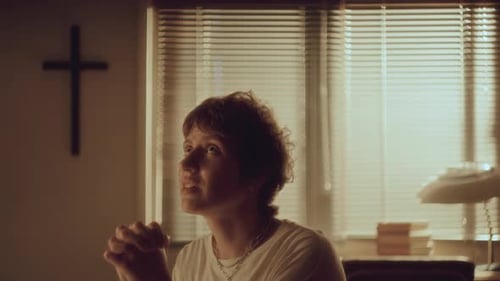 Adult Praying Indoors in Warm Light