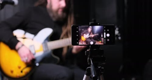 Guitarist Man Plays an Electric Guitar Closeup at Studio