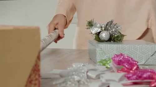 Woman preparing gifts on the table for christmas