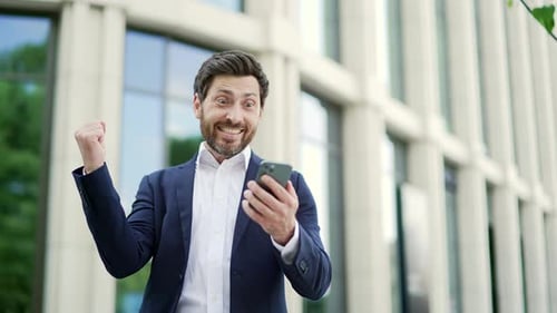 Happy Businessman Celebrates Success Outside Office Building