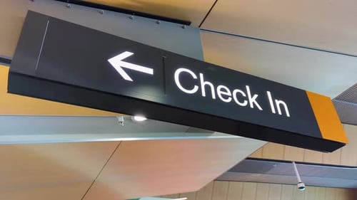 Passenger check in flashing sign with directional arrow at airport terminal