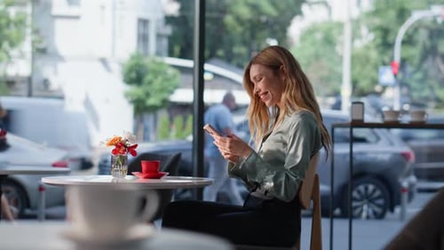 Cheerful Girl Watching Mobile Phone Social Media Sitting Cozy Cafeteria Alone