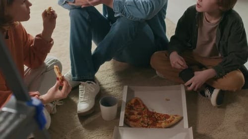 Family enjoying pizza together on the floor