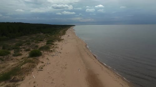 Sandy Beach Alongside Water Under Cloudy Sky Natural Coastal Landscape