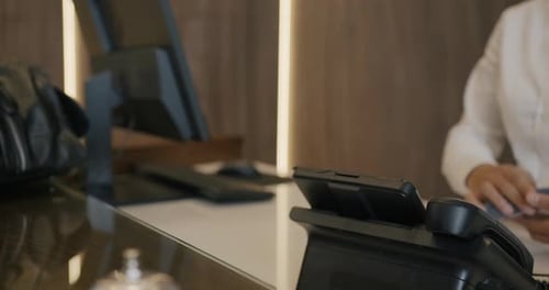 Closeup of Male Hand Holding Credit Card Making Cashless Payment in Hotel