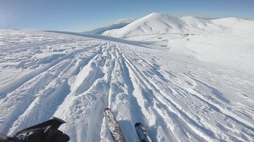 Skiing Downhill in a Snowy Mountain Landscape