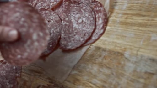 Fresh Italian Sliced Salami Sausage on a Wooden Cutting Board Cutting Heart Shapes of Milano Salami