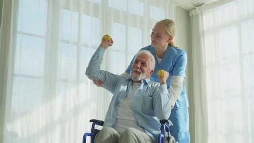 Senior Man Exercising with Assistance from Young Female Caregiver