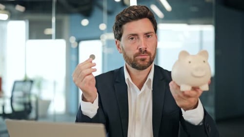 Thoughtful Businessman Saving Money With Piggy Bank