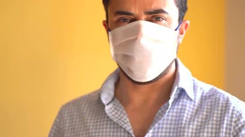 Man Wearing White Face Mask Looking at Camera