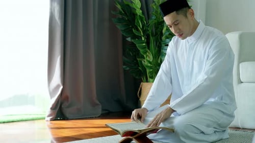 Portrait d'un musulman asiatique récitant le passage de la sourate al-Fatiha du Coran, lors d'une prière quotidienne à ho