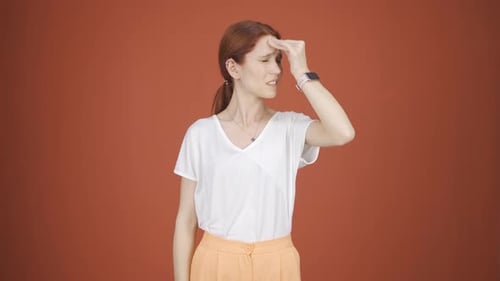 Woman with Headache Holding Forehead in Studio