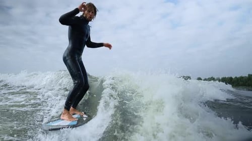 Surfer Gliding Effortlessly on Waves Showcasing Skill and Balance in Dynamic Water Scene