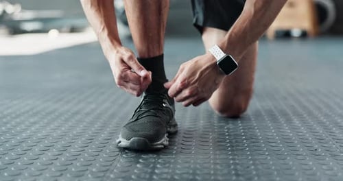 Man Tying Shoe Laces in Gym