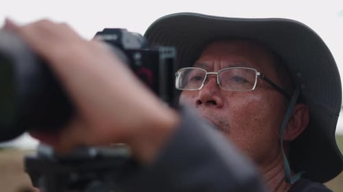 Adult Photographer Filming Nature Scene with Camera