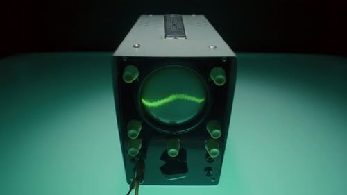 Dispositivo de osciloscópio analógico em estúdio escuro com iluminação azul-petróleo