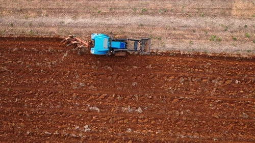 Aerial Shot of Blue Tractor Plowing Field