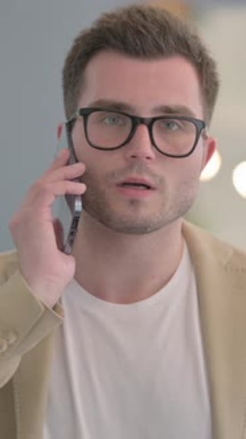 Young Man Talking on Smartphone, Indoor Setting