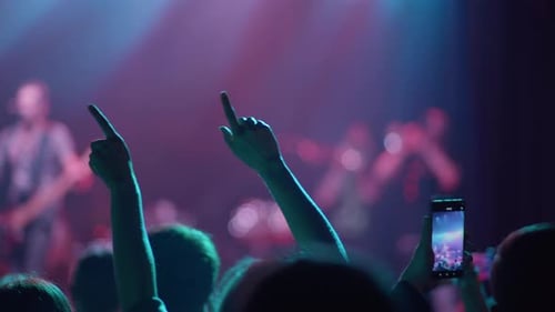 Fans machen Rock Handzeichen bei Konzert und Telefonfilmen