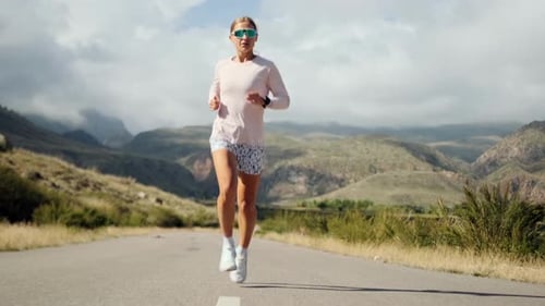 A Fit Woman in Pink Runs a Dry Valley Her Pace Reflecting Endurance