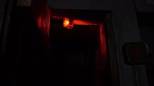 Closeup of a Rotating Red Emergency Siren Lamp on the Wall of a Dark Tunnel
