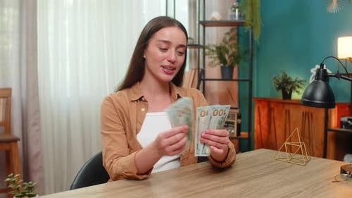 Young Woman Counting Money Dollars Cash Satisfied with Salary Earnings Celebrating Financial Success
