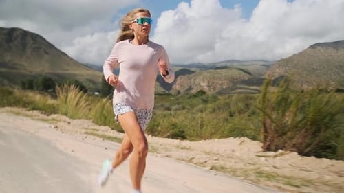 Athletischer Athlet läuft auf einer Bergstraße und bereitet sich auf den Wettkampf vor