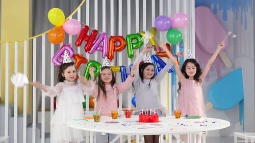 Girls Celebrate Birthday at Party with Cake and Balloons