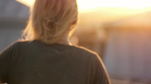 Young Adult with Balloon on Rooftop at Sunset