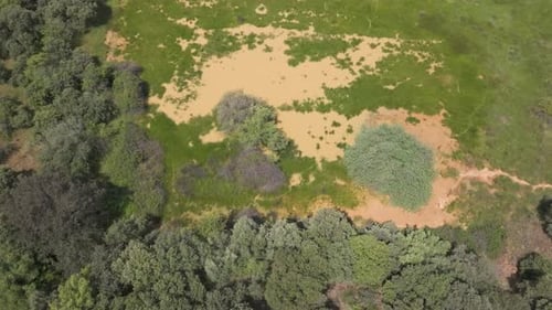 Top view drone descent over flooded rural field with muddy brown water