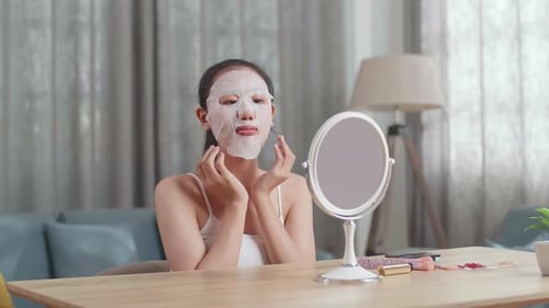 Young Woman Applying Sheet Mask At Home