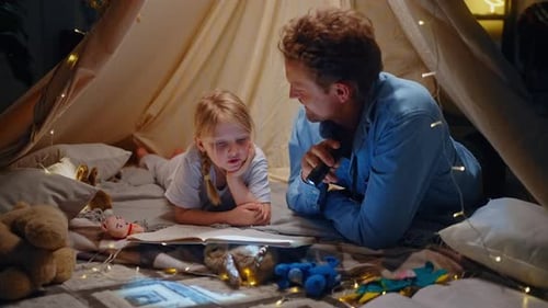 Father and Daughter Reading Under Blanket Tent