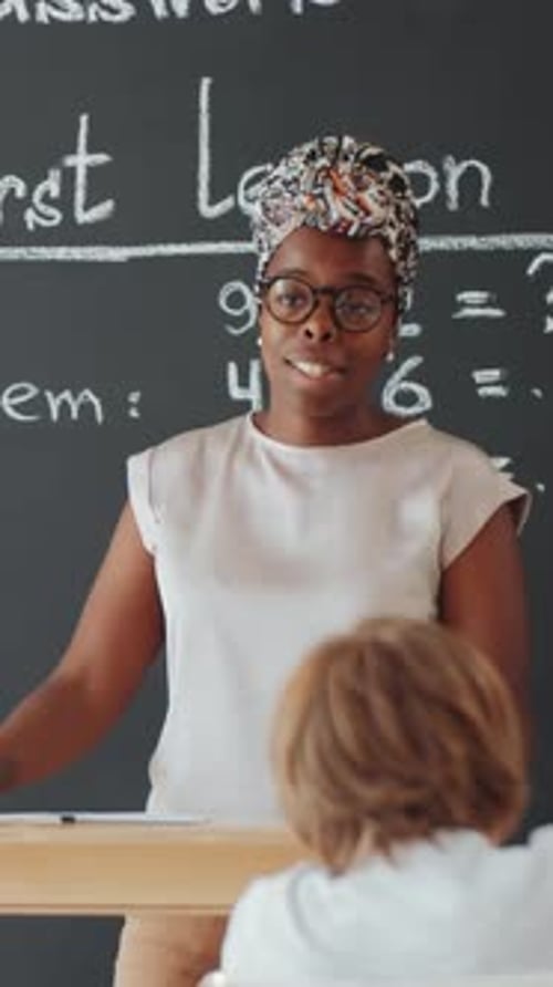 African American Educator Teaching Children, Raising Hands in School