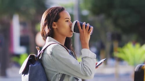 Young Woman Drinks Coffee in City