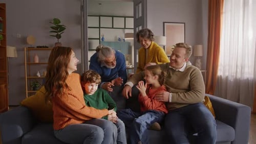 Family Gathering on Couch in Warmly Lit Home