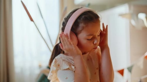 Girl with headphones dancing in her bedroom
