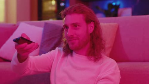 Man Relaxing on Sofa at Home Watching TV