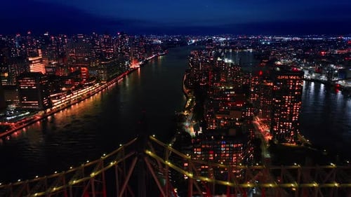 Flying above the Queensboro Bridge over the East River at night.
