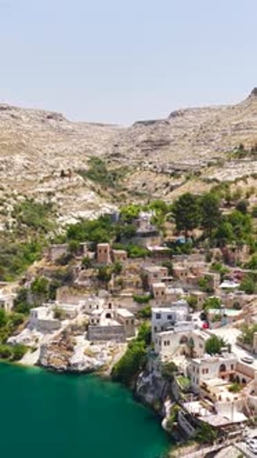 Vidéo verticale : vieille ville de Halfeti avec mosquée entourée d'eau et d'espaces verts