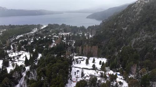 Snow-Covered Winter Landscape with Houses by a Large Lake