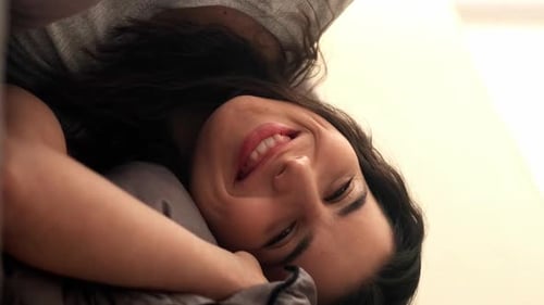 Smiling Woman Relaxing on Bed at Home