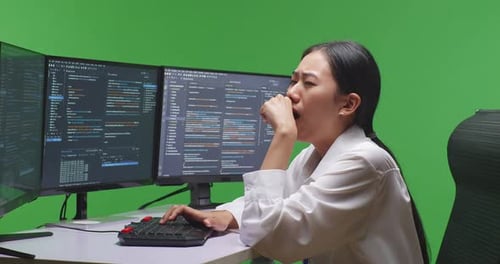 Woman Developer Yawning Before Sleeping While Write Code With Multiple Screens In Green Screen