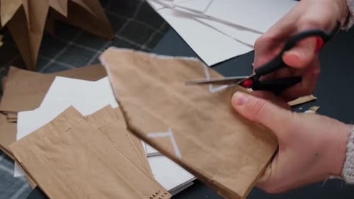 Woman Cutting Brown Paper Bag with Scissors