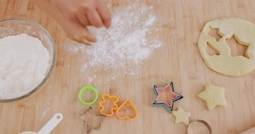 Child sprinkles flour for cookie baking