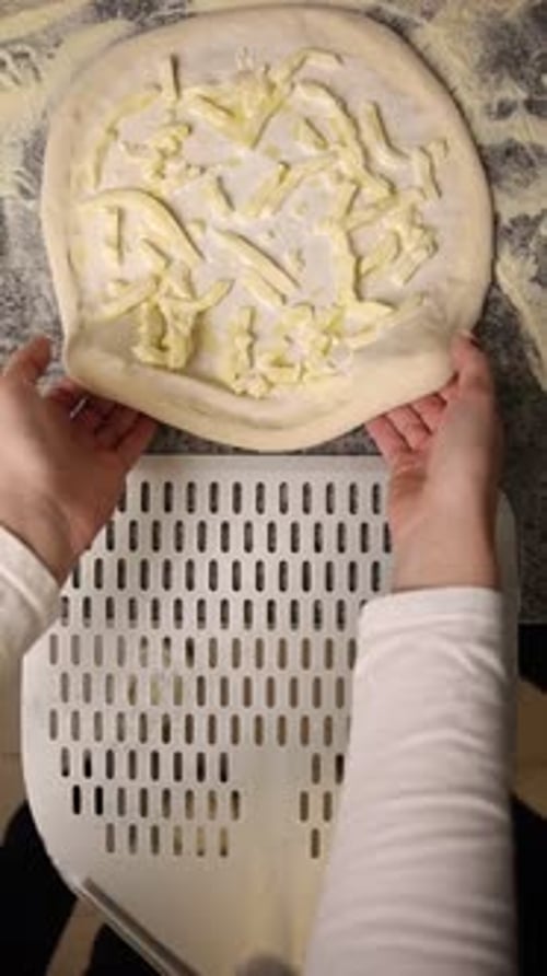 Hands Preparing Pizza Dough with Cheese Topping